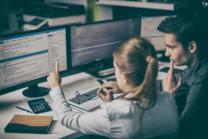 A woman and man looking at a computer screen.